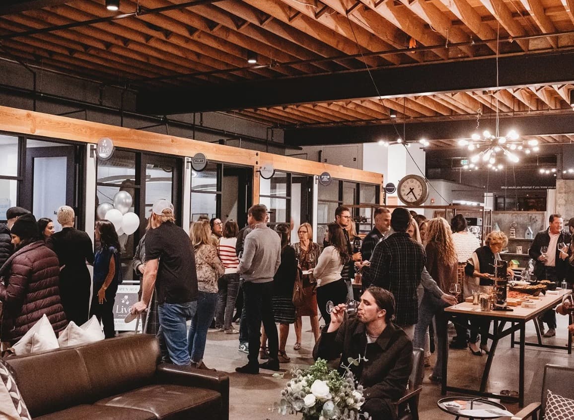 A full-building evening party at CraftWork Healdsburg, guests spread across the lounge and the open floor
